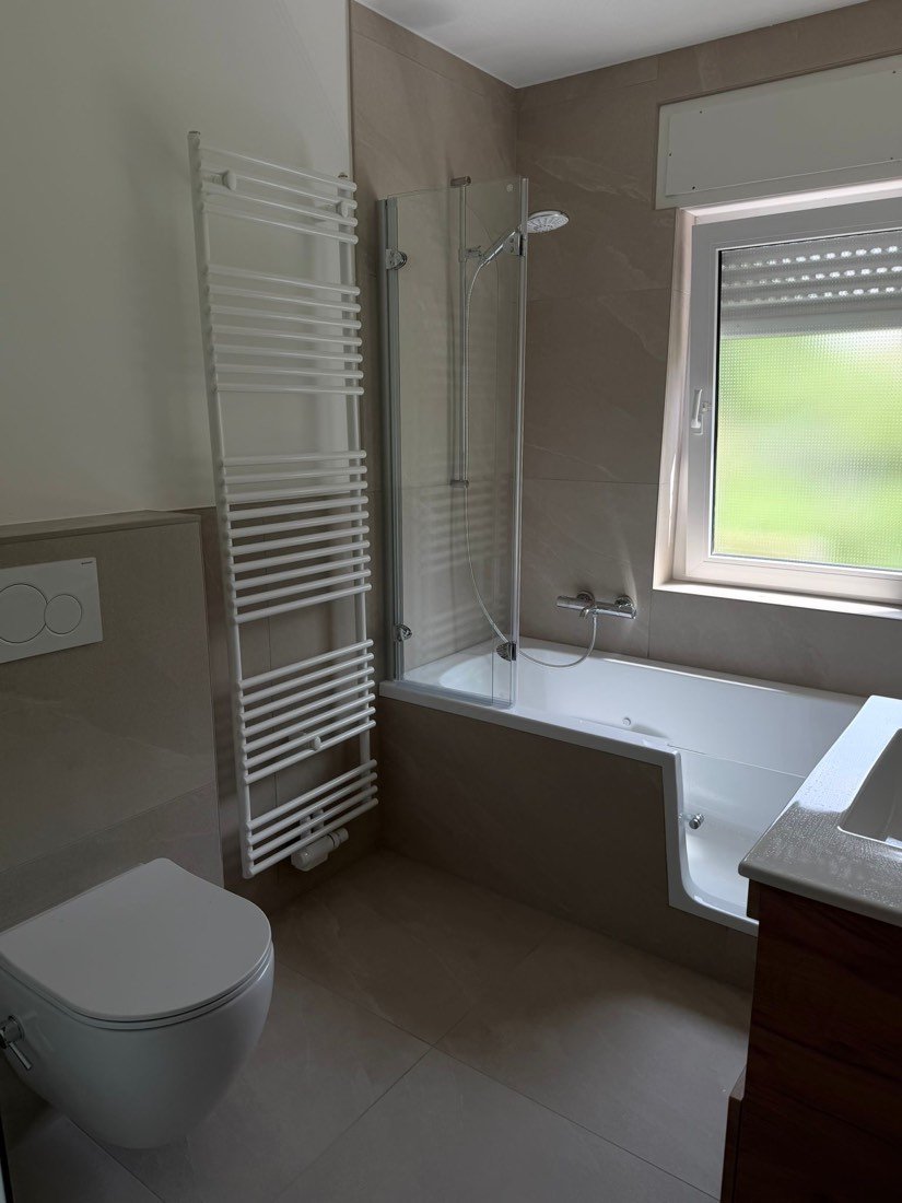 Neu gefliestes Bad mit Badewanne am Fenster
