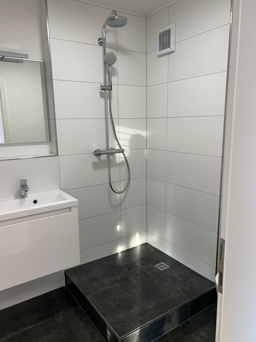 Weiße Dusche mit schwarzer Steinablage